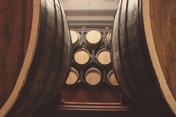 Wooden barrels with whiskey in dark cellar. Modern production of whiskey with the observance of...