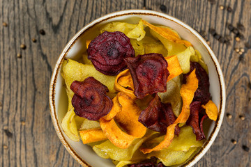 homemade beetroot, potato and carrot chips on wood