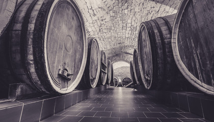 Old oak barrels in an ancient wine cellar. Ancient wine cellar in the ancestral castle. Century...