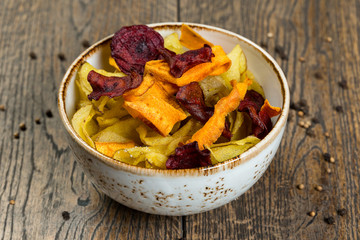 homemade beetroot, potato and carrot chips on wood