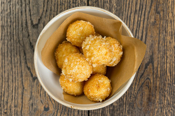 fried cheese balls in breading on a wooden table