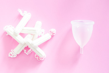 Zero waste concept - menstrual cup as alternative to tampons and traditional female hygiene, pink background
