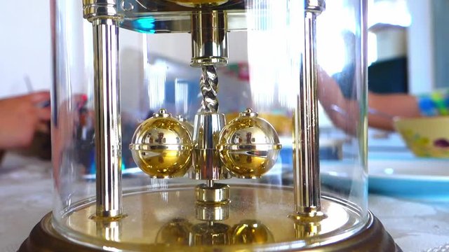 Close up of spinning weights on a dome style carriage clock