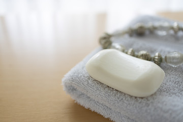 Fototapeta na wymiar Weiße Seife auf Handtuch mit Kette