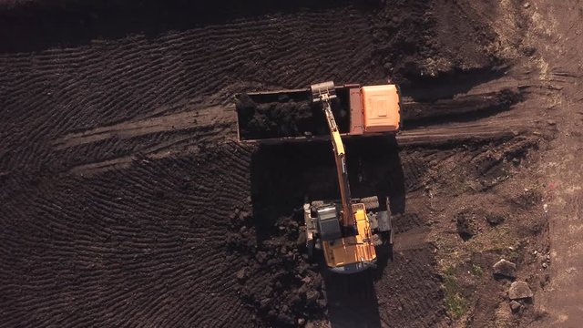 Top down view of construction site with machinery, truck, excavator.