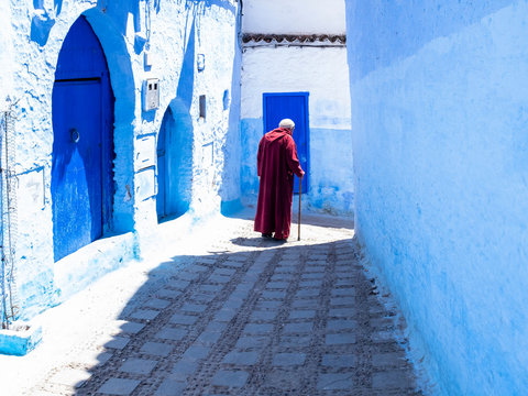 Anciano con  bastón paseando por las calle de Chauen, Marruecos