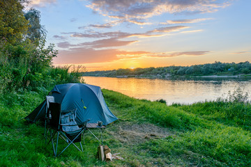 Camping tent in a camping in forest by the river - obrazy, fototapety, plakaty