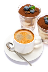 Classic tiramisu dessert with blueberries in a glass and cup of coffee isolated on a white background with clipping path