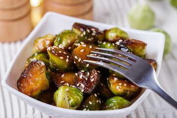 Roasted Brussels sprouts in a white bowl on a wooden background