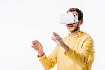 young man in yellow hoodie using virtual reality headset isolated on white