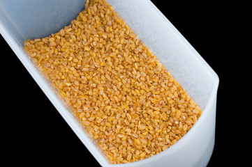 whole grain brown rice with an edible shell removed in an airtight plastic storage container.