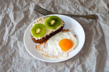 Delicious and healthy breakfast. Scrambled eggs and kiwi sandwich