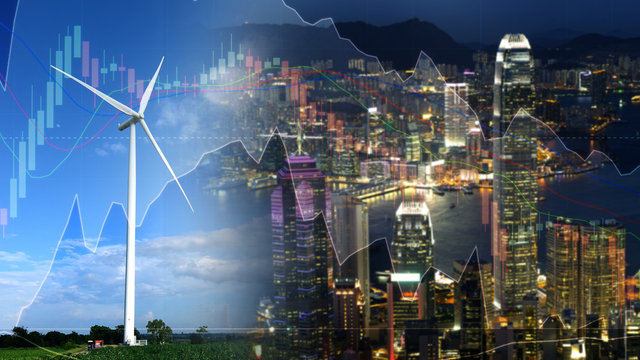 double exposure wind turbine and cityscape investment stock graph concept.