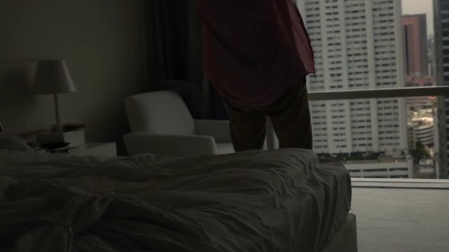 Silhouette of happy man falling on bed at home, super slow motion 240fps