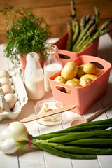 Fresh asparagus potatoes and eggs on white  kitchen table