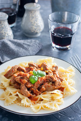 Beef in tomato sauce with farfalle, selective focus
