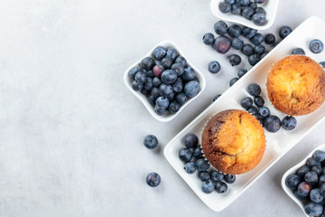 Muffins and blueberries on a white kitchen table.