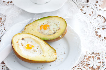 Baked with avocado egg for breakfast on a white plate, horizontal