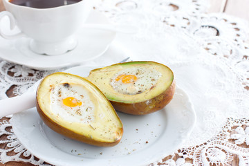 Baked with avocado egg for breakfast on a white plate, horizontal