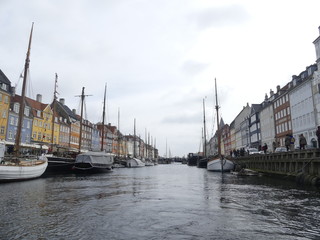 Fototapeta premium COPENHAGEN, DENMARK - MARCH 2019: View of Nyhavn. Boats stand on the Nyhavn pier in the city center.