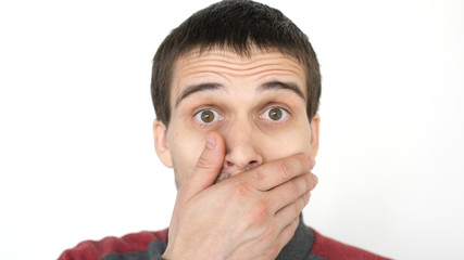 Close-up of a surprised emotional man with brown eyes looking into the camera.