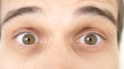 Close-up of a surprised emotional man with brown eyes