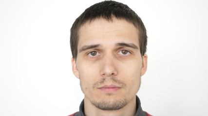 Obraz premium Portrait of young attractive upset man looking at the camera on a white background.