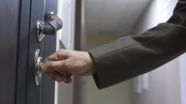 A man unlocks a house's door with key and enters. 3840x2160