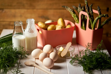 Fresh asparagus potatoes and eggs on white  kitchen table