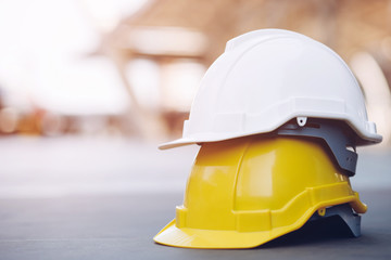 yellow and white hard safety wear helmet hat in the project at construction site building on...