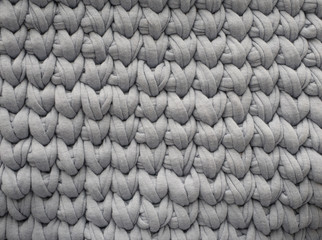 Closeup cotton grey knit blanket, warm and comfortable atmosphere. Knit background