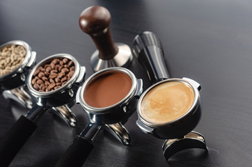 four holders with green, roasted, ground, and hot coffee and tamper, equipment for making freshly brewed coffee