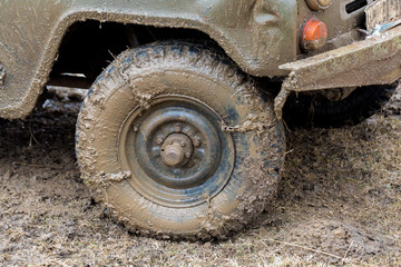 Fototapeta na wymiar Rally on Russian SUVs in the mud in winter, Trapped all-terrain vehicle pulled out of the river