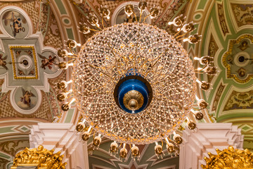 Fototapeta na wymiar Crystal chandelier of the Peter and Paul Cathedral in Saint Petersburg, Russia from below with its ornate canopy