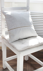 Fototapeta na wymiar linen pillows on a white chair, ecological material in the interior