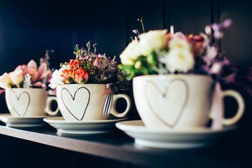 white cup with flowers on the black shelf. cup with roses for Mother's Day. Valentine's Day.