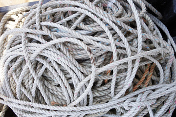 coils of used and grungy nylon white lobster trap rope Horizontal