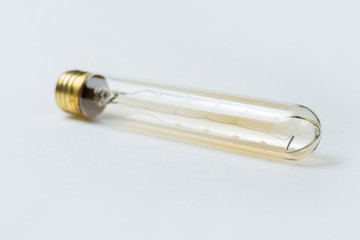 Edison bulb on white background. Vintage light bulb with golden base.