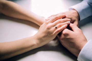 Obraz na płótnie Canvas male hands are holding female hands. female hand with a wedding ring. reliable male hands. strong male hands.