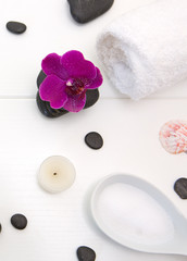 Fototapeta na wymiar Spa setting with pink orchids , black stones and candle on wood background.