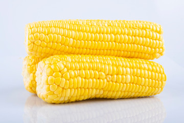 fresh raw sweet corn on the cob kernels over white background