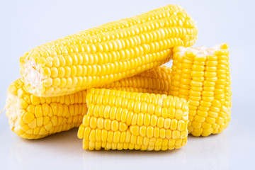fresh raw sweet corn on the cob kernels over white background