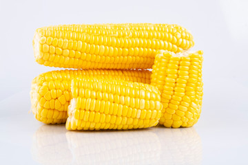 fresh raw sweet corn on the cob kernels over white background