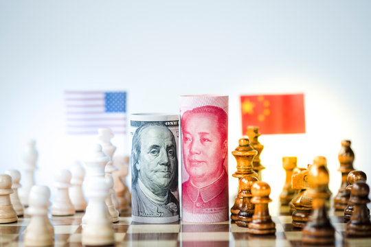 US dollar and Yuan banknote with chess for tariff trade war between United States and China which both countries battle by increase tax barrier of import and export product. Government and business.