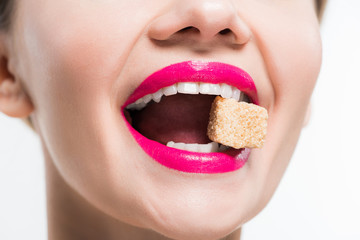 Fototapeta premium cropped view of happy woman eating sugar cube isolated on white