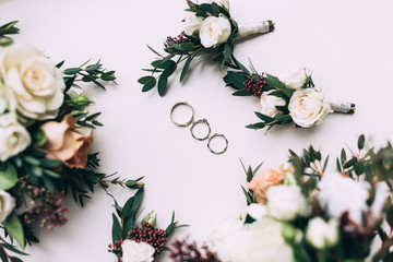 Silver rings newlyweds on the table with a wedding bouquet.