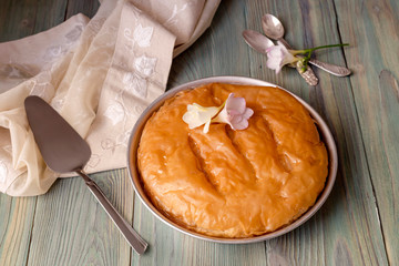 Milk pie with sauce on a wooden table