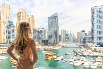Keuken foto achterwand Dubai Vrouw in Dubai Marina, Verenigde Arabische Emiraten. Aantrekkelijke dame die een lange jurk draagt en het daglicht van Marina bewondert