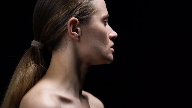 Woman taking off weak label from ear, protest against gender discrimination