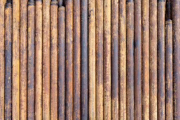 Rusty grunge pipes horizontal background. Orange corrosion rust on steel metal factory industrial pattern. Rough texture brown parallel stack close up